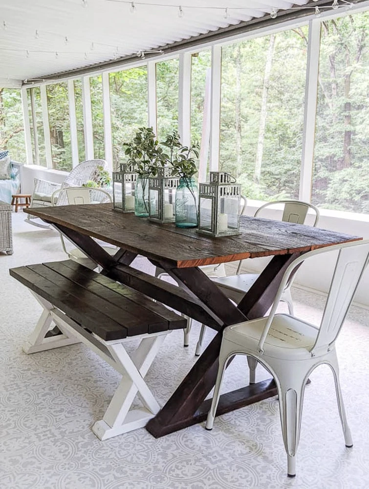 DIY Farmhouse table on screened-in porch with DIY wood bench and metal chairs.
