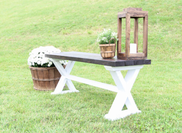 finished diy farmhouse style wood bench with white painted legs and a dark stained bench top.