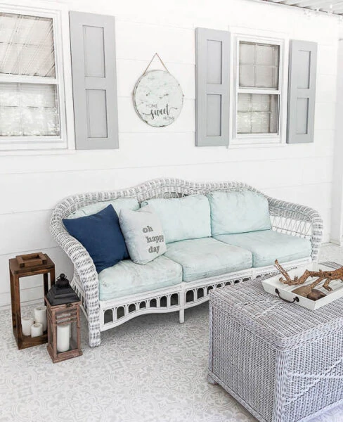 finished diy shutters hanging on screened-in porch with patio furniture and decor.