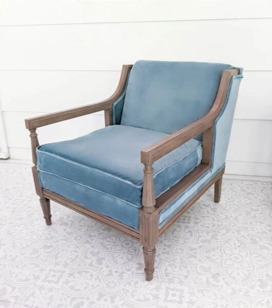 Chair reupholstered with blue velvet fabric with a painted wood frame.