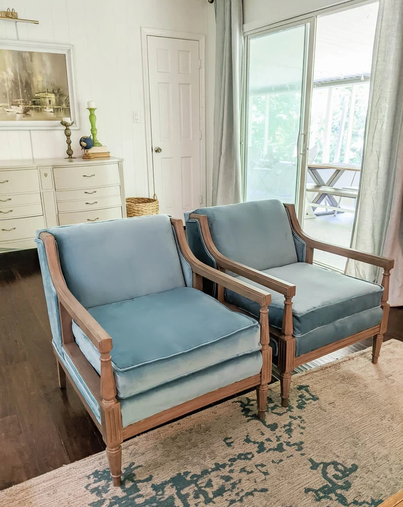 Pair of vintage chairs reupholstered with blue velvet fabric in living room. 
