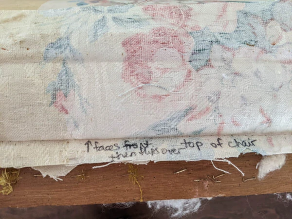 Piece of old upholstery fabric labeled with a marker to show where on the chair it goes.