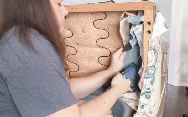 Attaching the new upholstery fabric with a staple gun.