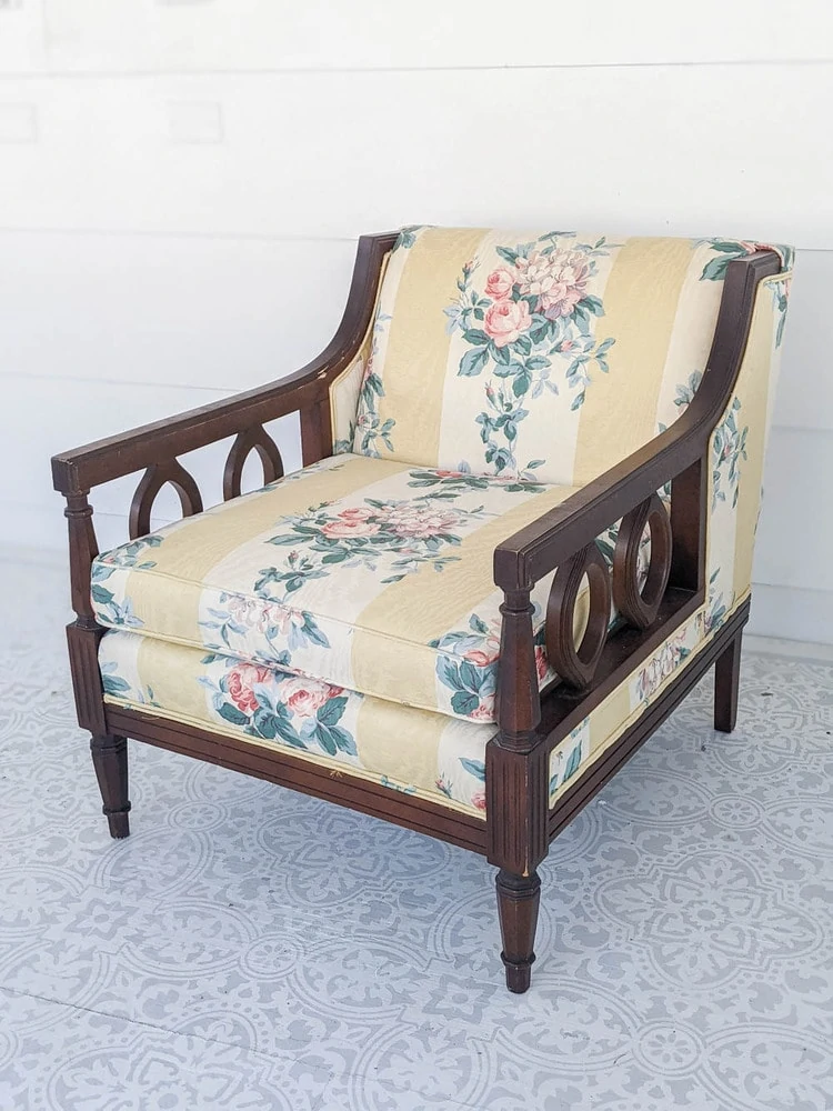 Vintage chairs before reupholstery with dark wood arms and yellow striped floral fabric.