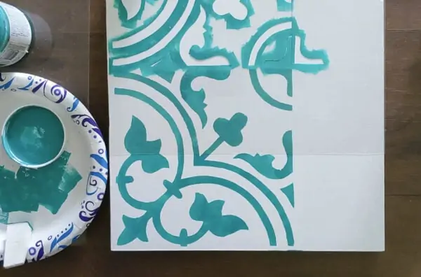 Stenciling a sample board with my DIY tile stencil and lining up the repeating design using the registration marks.
