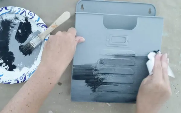 Rubbing a black color wash onto a wall pocket painted gray.