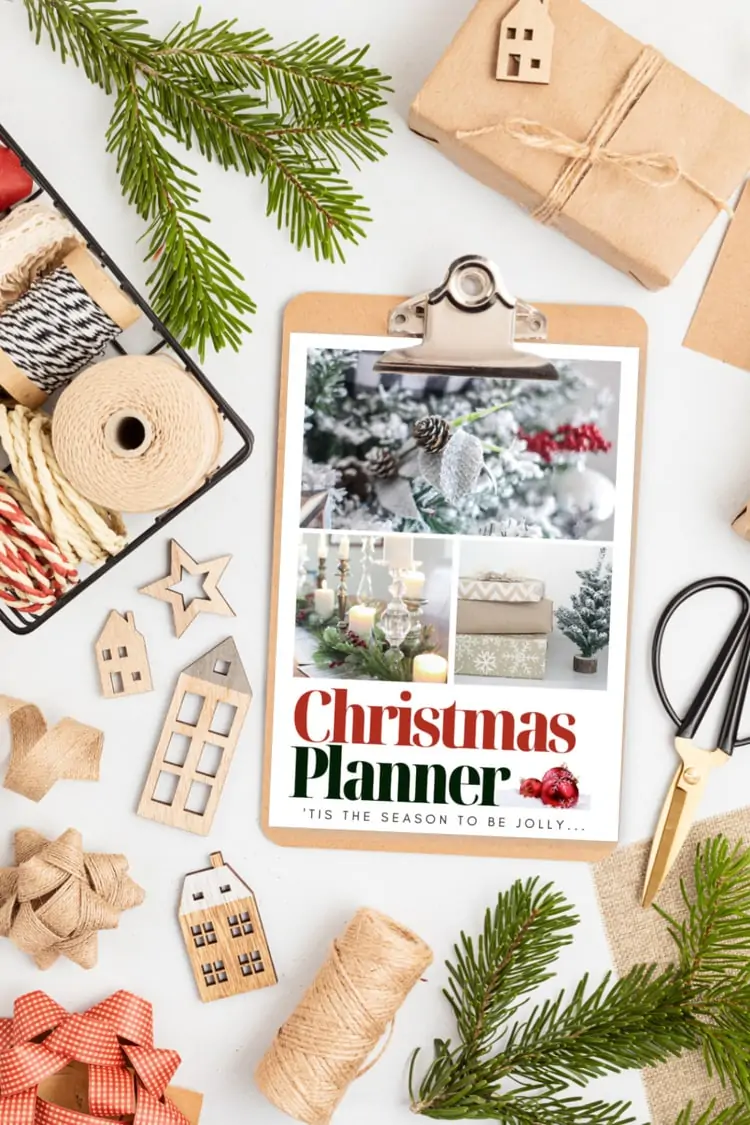 cover of free Christmas planner on clipboard surrounded by Christmas decor.
