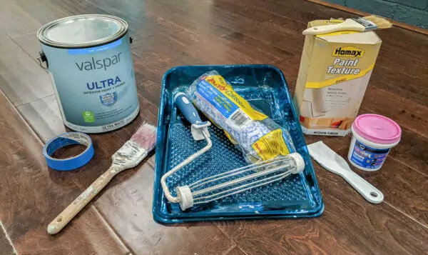 supplies for painting ceiling - flat paint, painter's tape, angled paint brush, paint tray, paint roller, paint roller cover, spackling, putty knife, paint texture additive, chip brush