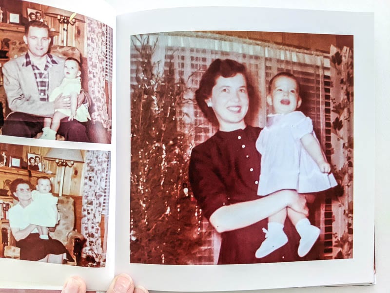 photo book open to sepia photos of mom holding baby in front of Christmas tree.