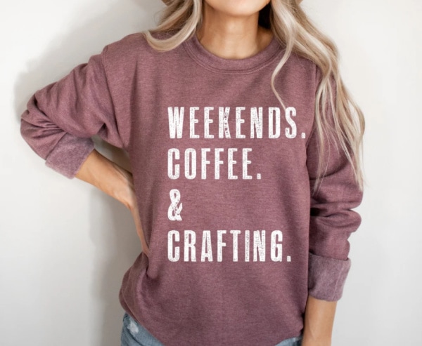 mauve sweatshirt that says weekends, coffee, & crafting.