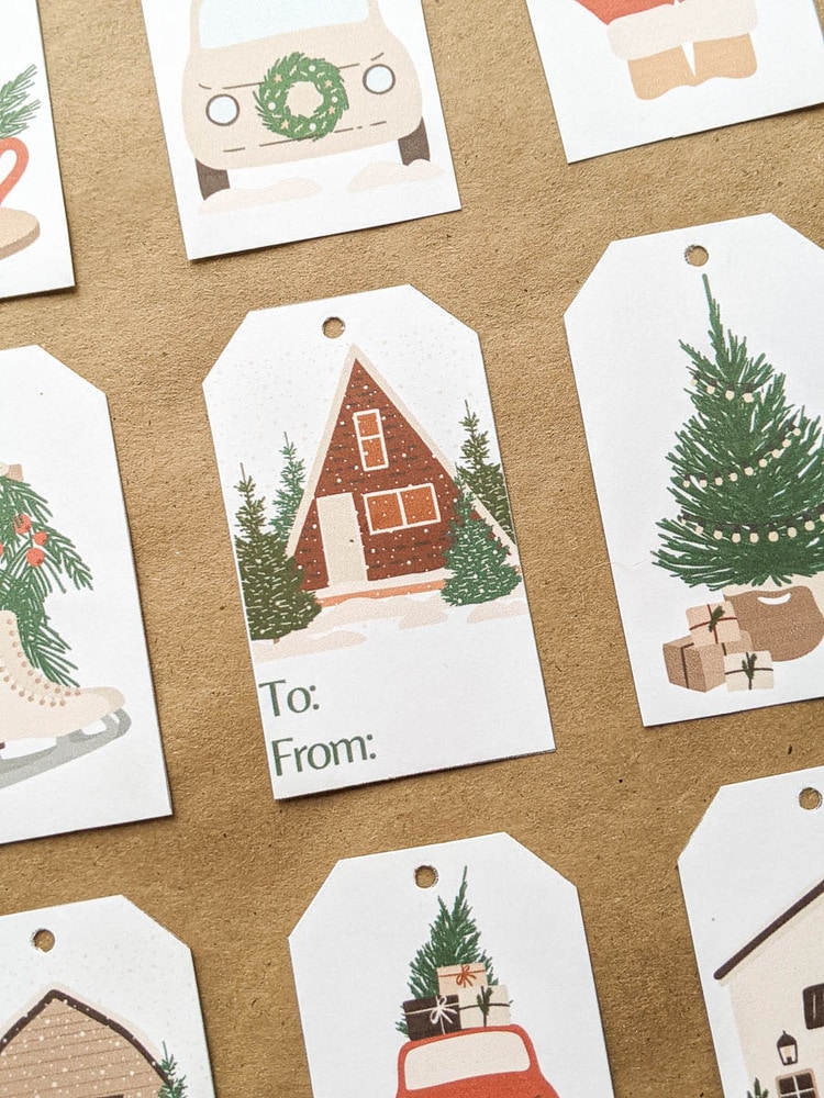 closer view of Christmas gift tags with Christmas tree, car with wreath on front, and house in the snow.
