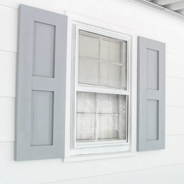 diy wood shutters painted gray hanging on white siding.