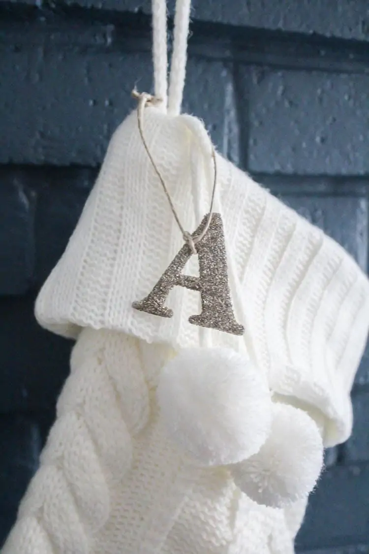 white stocking with silver glittered A attached with twine.