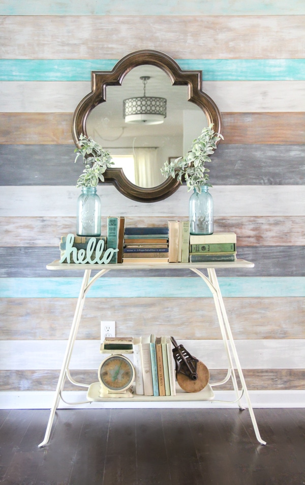 entryway with a quatrefoil mirror hung above a table to bounce light into the room.
