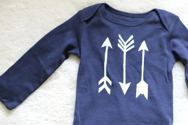 navy onesie with white arrows stenciled on it.