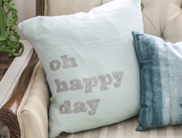 blue pillow the 'oh happy day' stenciled on it.