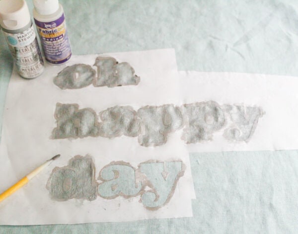 filling in the oh happy day stencil with silver paint.