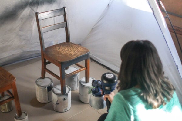 using paint sprayer to paint chairs