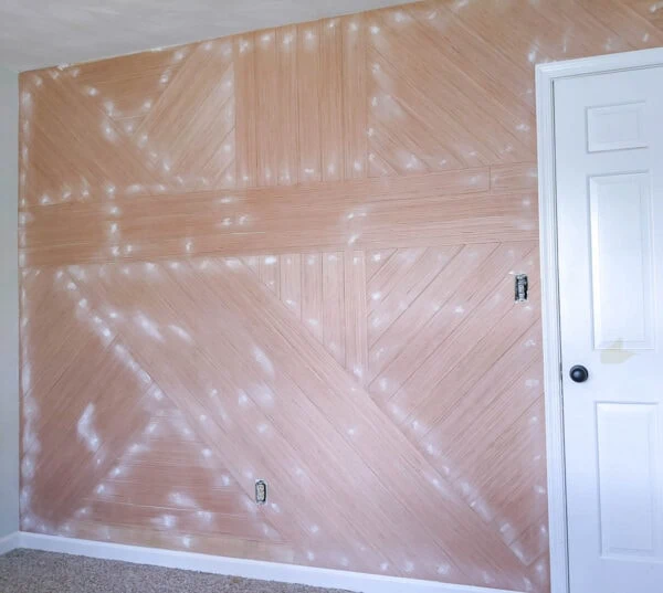 Wood wall after spackling and sanding the nail holes.