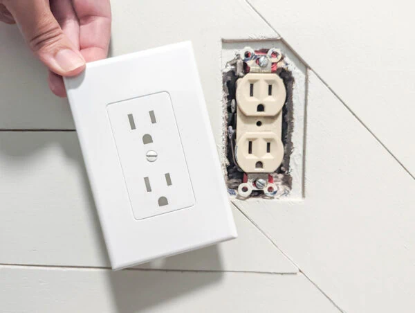 putting revive outlet cover over old beige electrical outlet.
