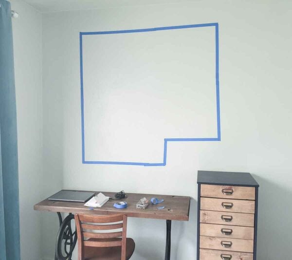 painter's tape outline on wall above desk.
