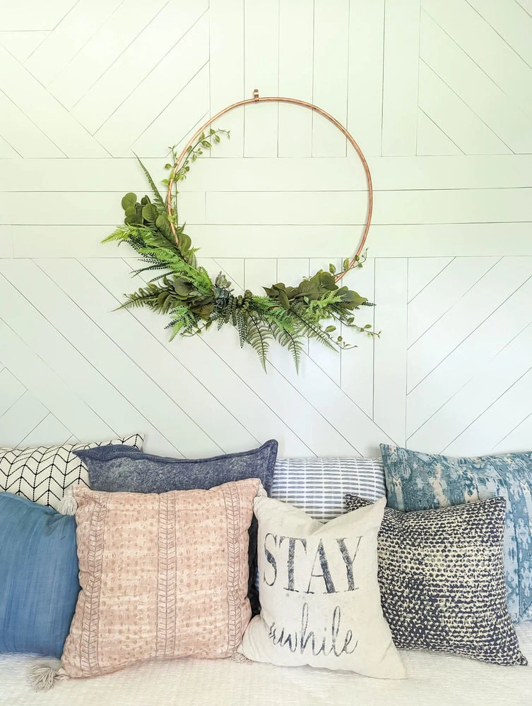 DIY copper wreath on geometric wood wall.