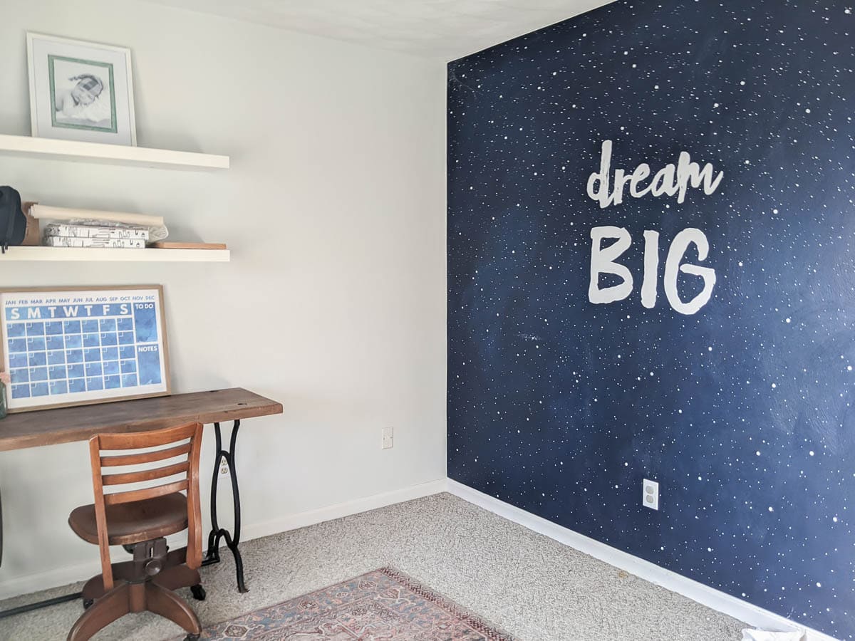 Dream Big mural with crib and dresser gone and a desk and desk chair in their place.