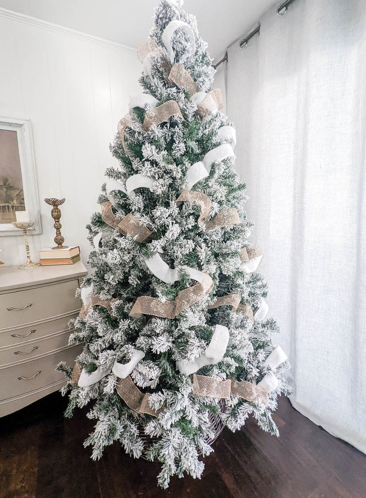 Christmas tree decorated with white and gold ribbon throughout.
