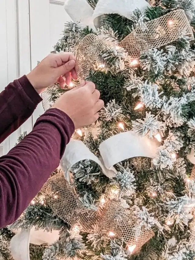 putting ribbon on a christmas tree.