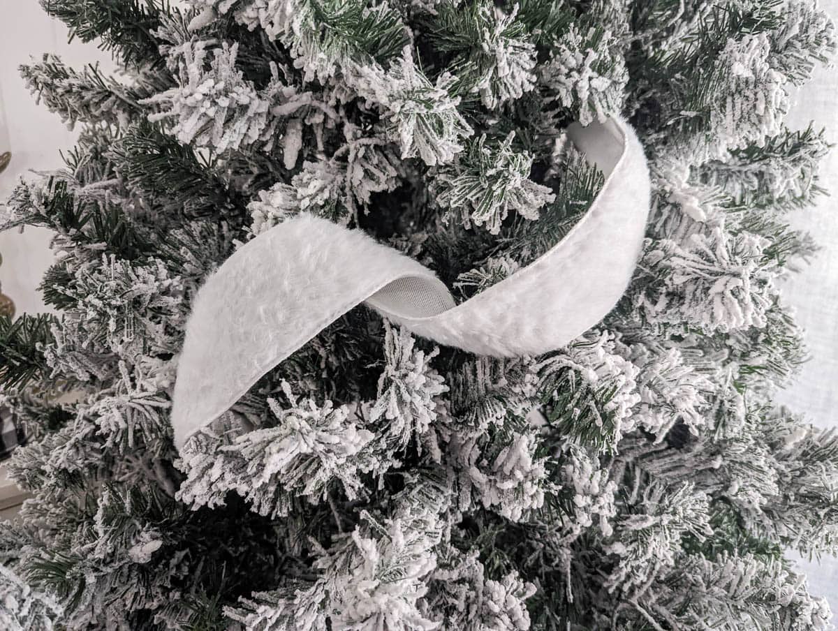 piece of ribbon curled into a loop and tucked into Christmas tree.