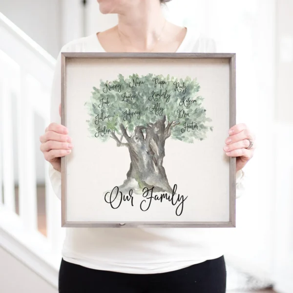 someone holding framed family tree sign.