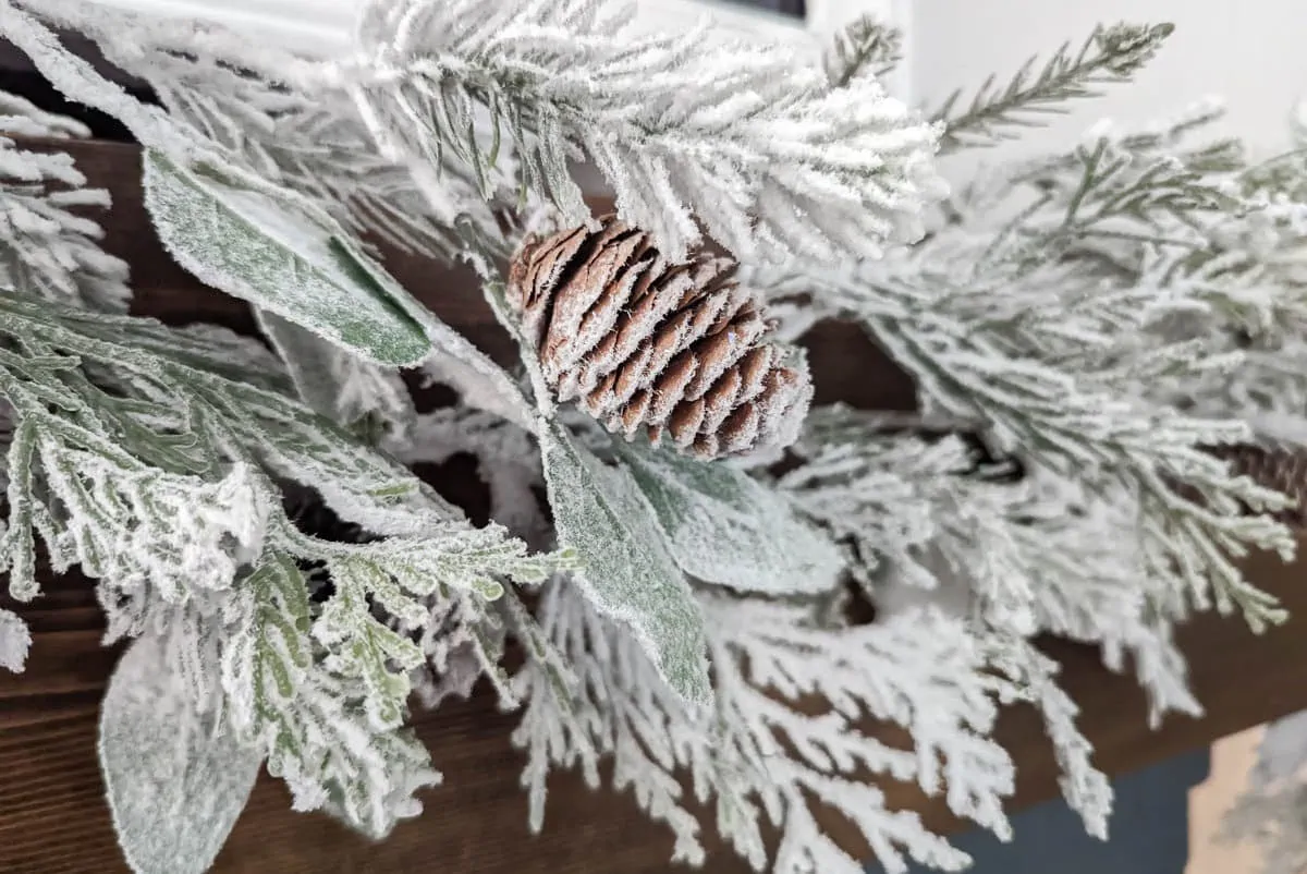 close up of flocked garland with pinecone.