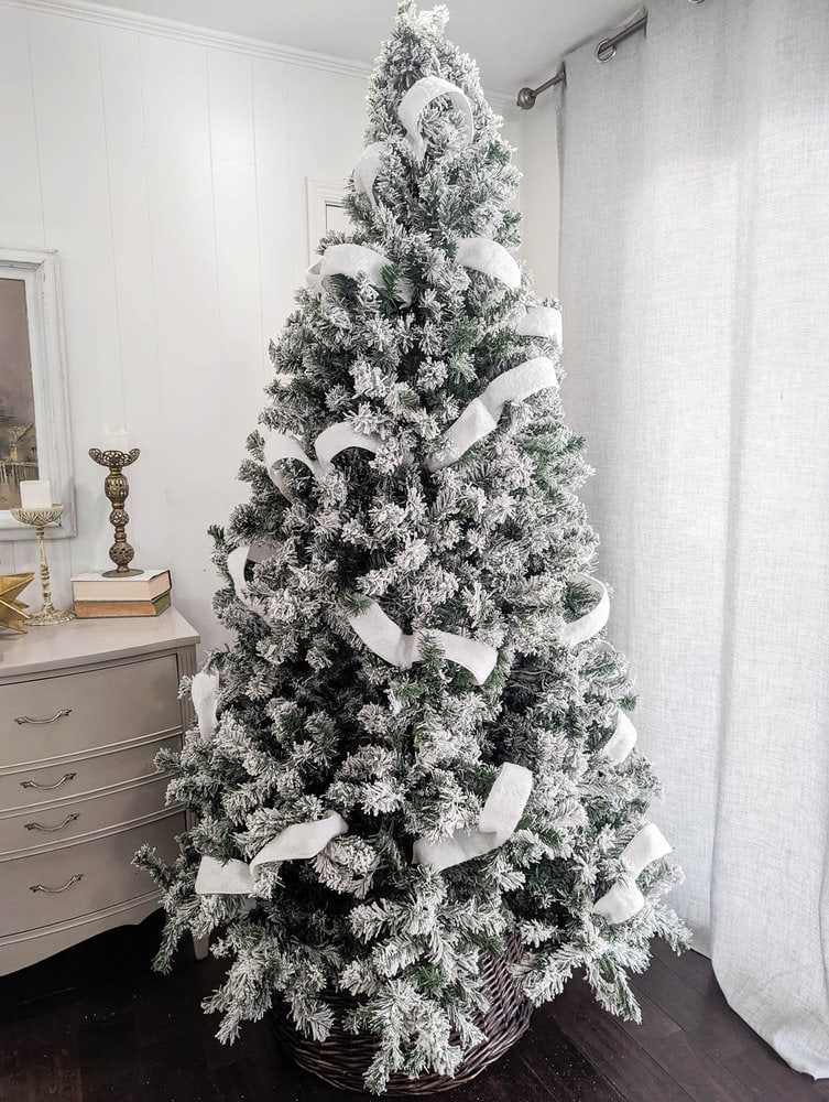 Christmas tree with white ribbon throughout.