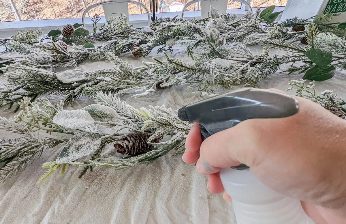 spraying water on flocked garland.