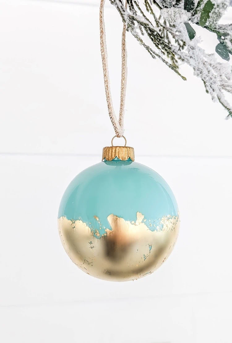 clear ball ornament painted aqua with gold leaf on lower half.