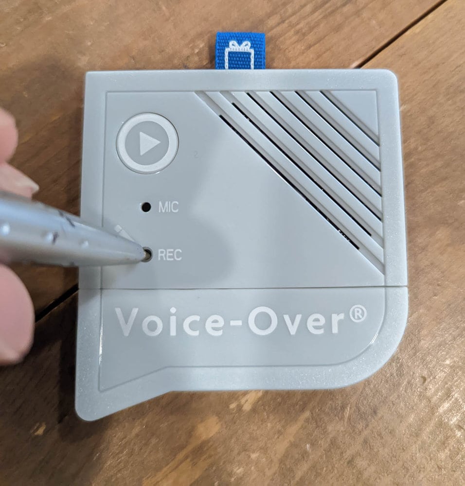 pushing record button on voice recorder with a pen.