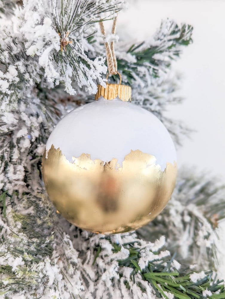 clear ball ornament painted white with gold leaf on lower half.