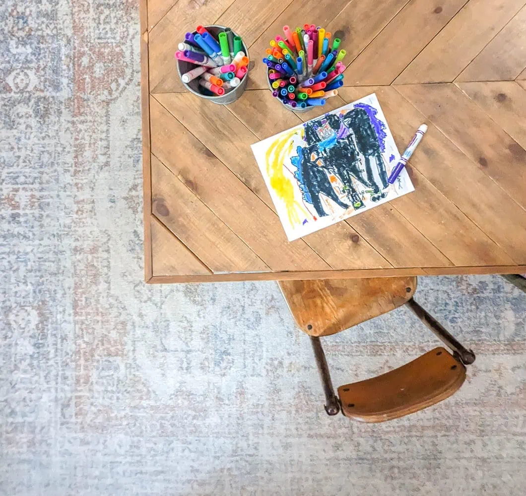 coffee table with kids art supplies sitting on top of washable rug.