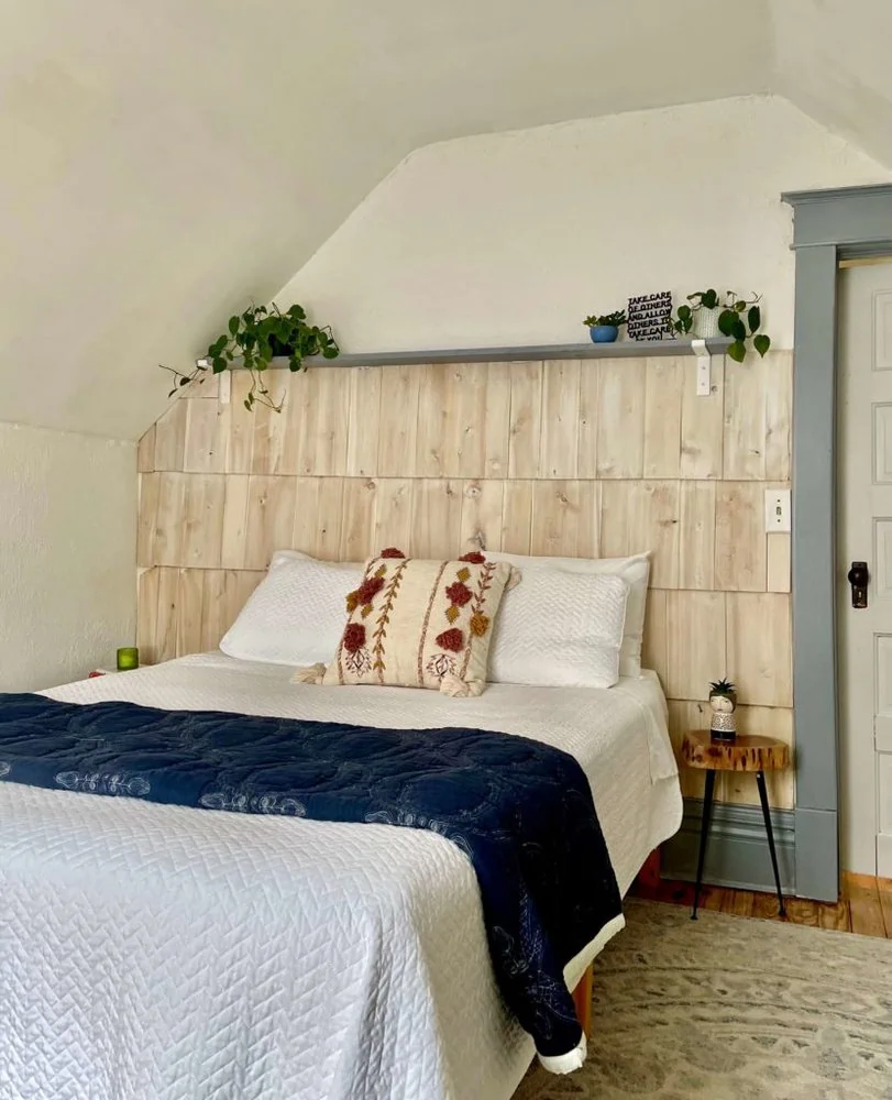 Wood accent wall behind bed made using cedar shakes.