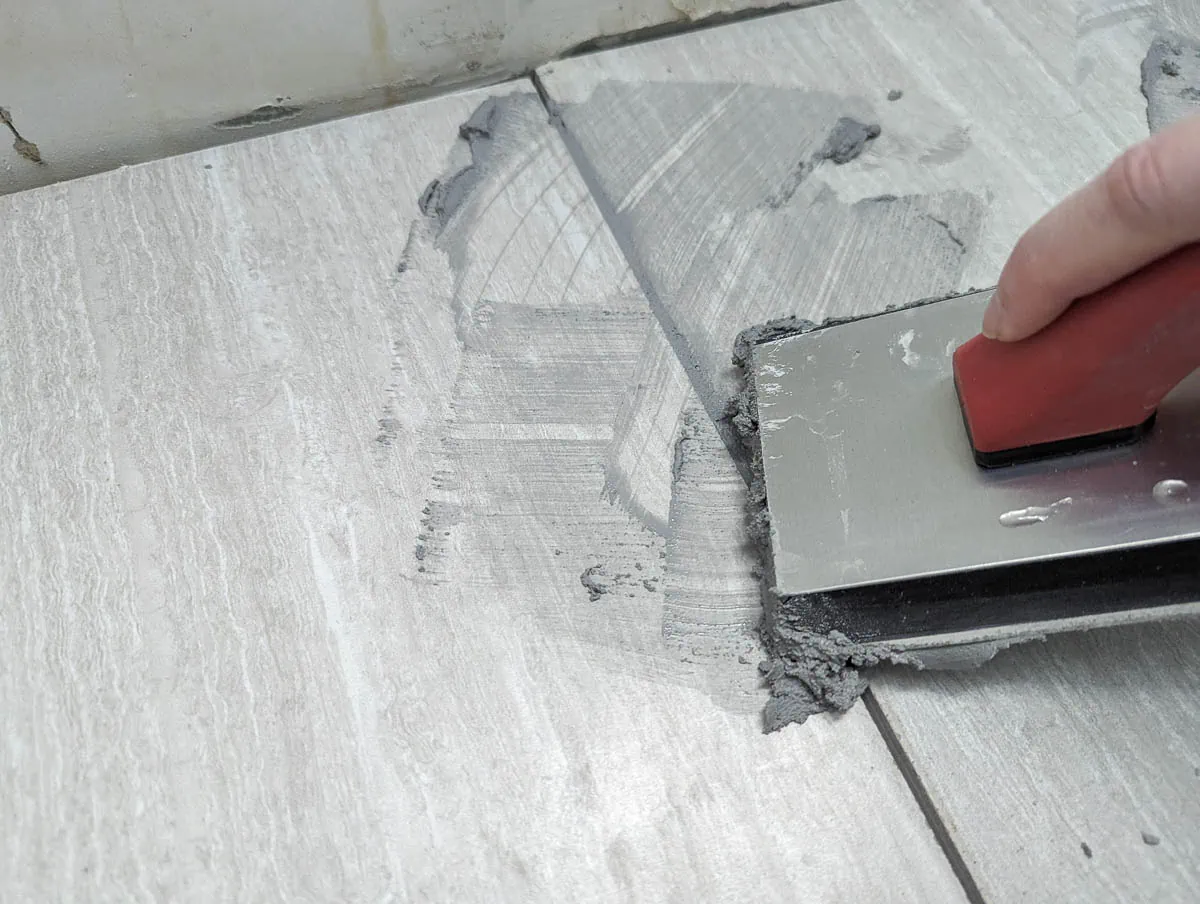 applying new grout with a grout float.