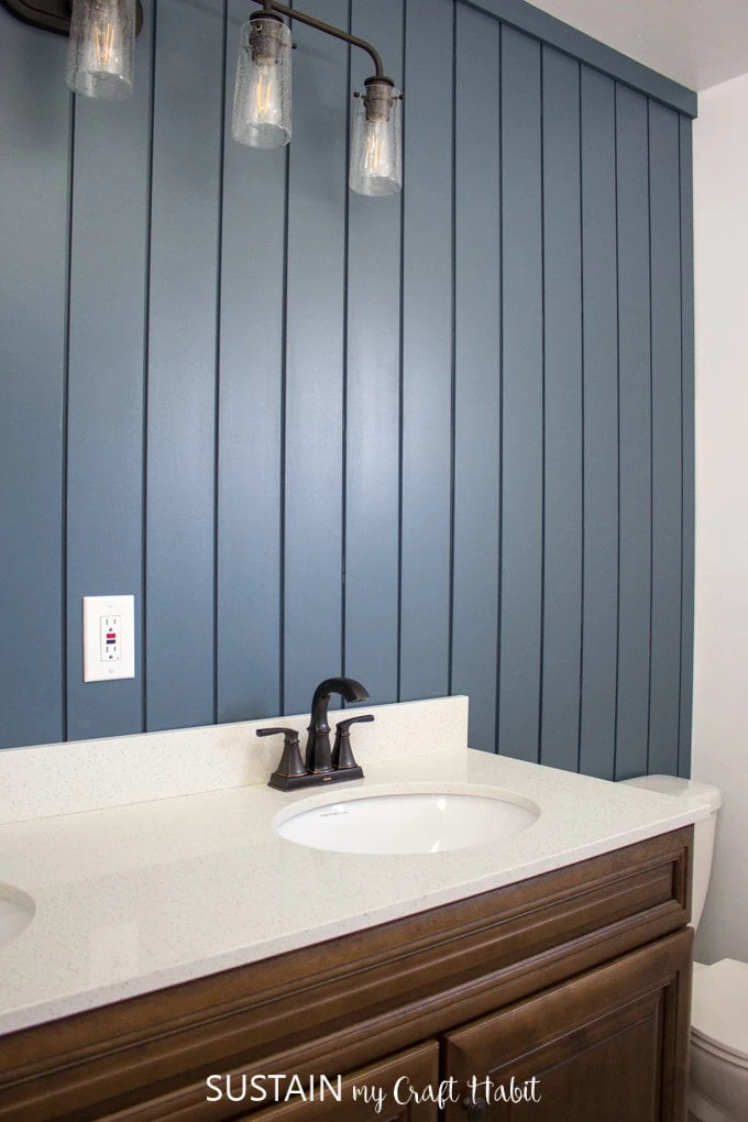 Bathroom with dark blue painted vertical shiplap.