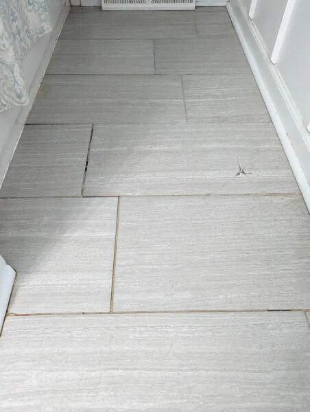 tile floor with stained and crumbling grout.