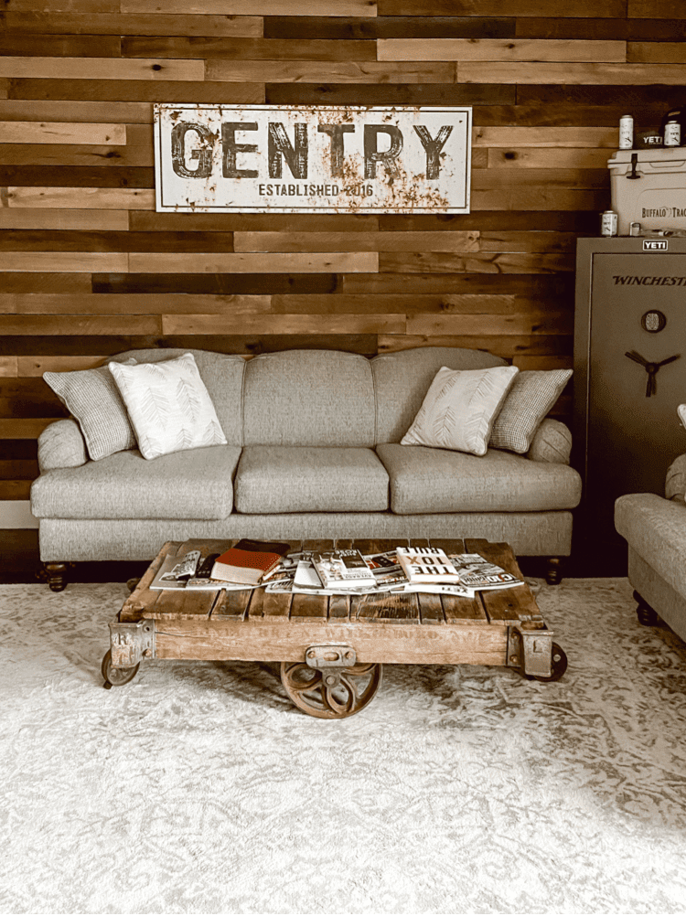 Living room with wood accent wall in various shades of dark brown behind couch.