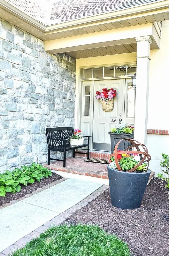 small front porch with a bench next to the front door.