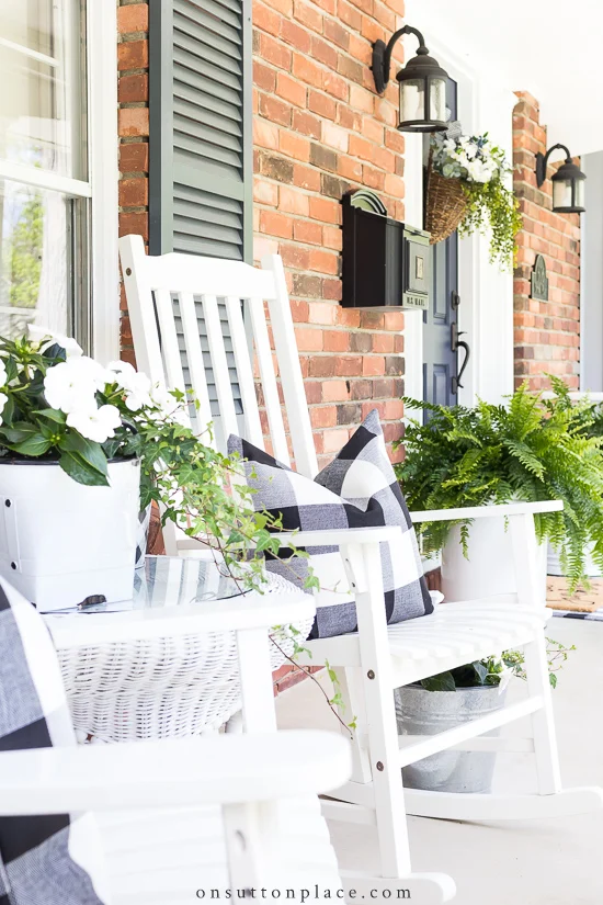 white rocking chairs and lots of green plants on front porch.