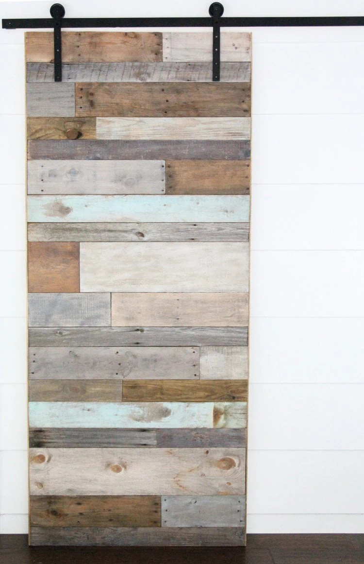 oversized barn door made with planks of various reclaimed wood.