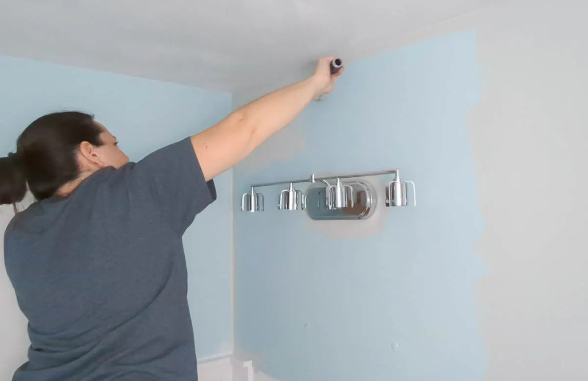 filling in wall with paint roller.