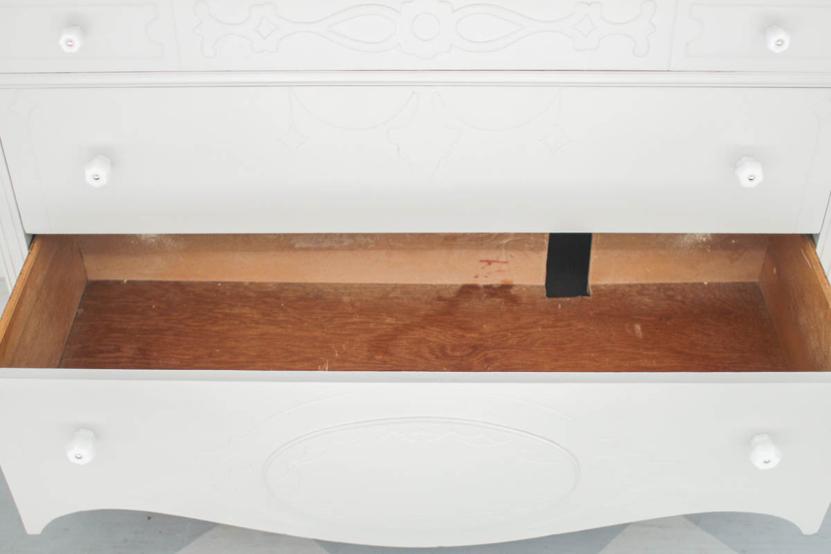small sliver cut from back of bottom drawer in dresser bathroom vanity.