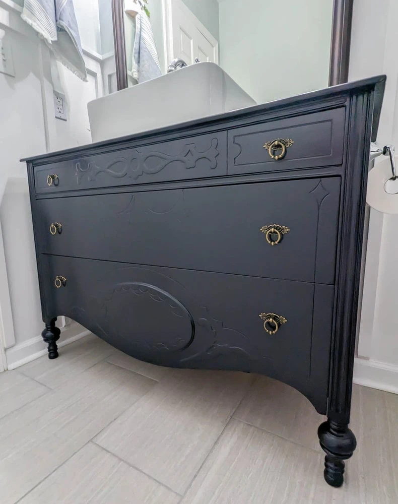 navy blue dresser with brass hardware.