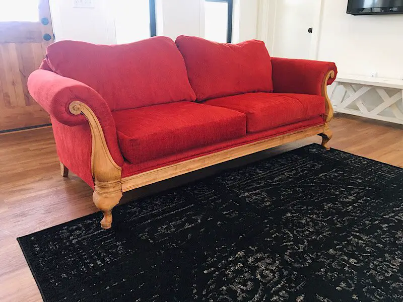 sofa with rolled arms reupholstered with red fabric.